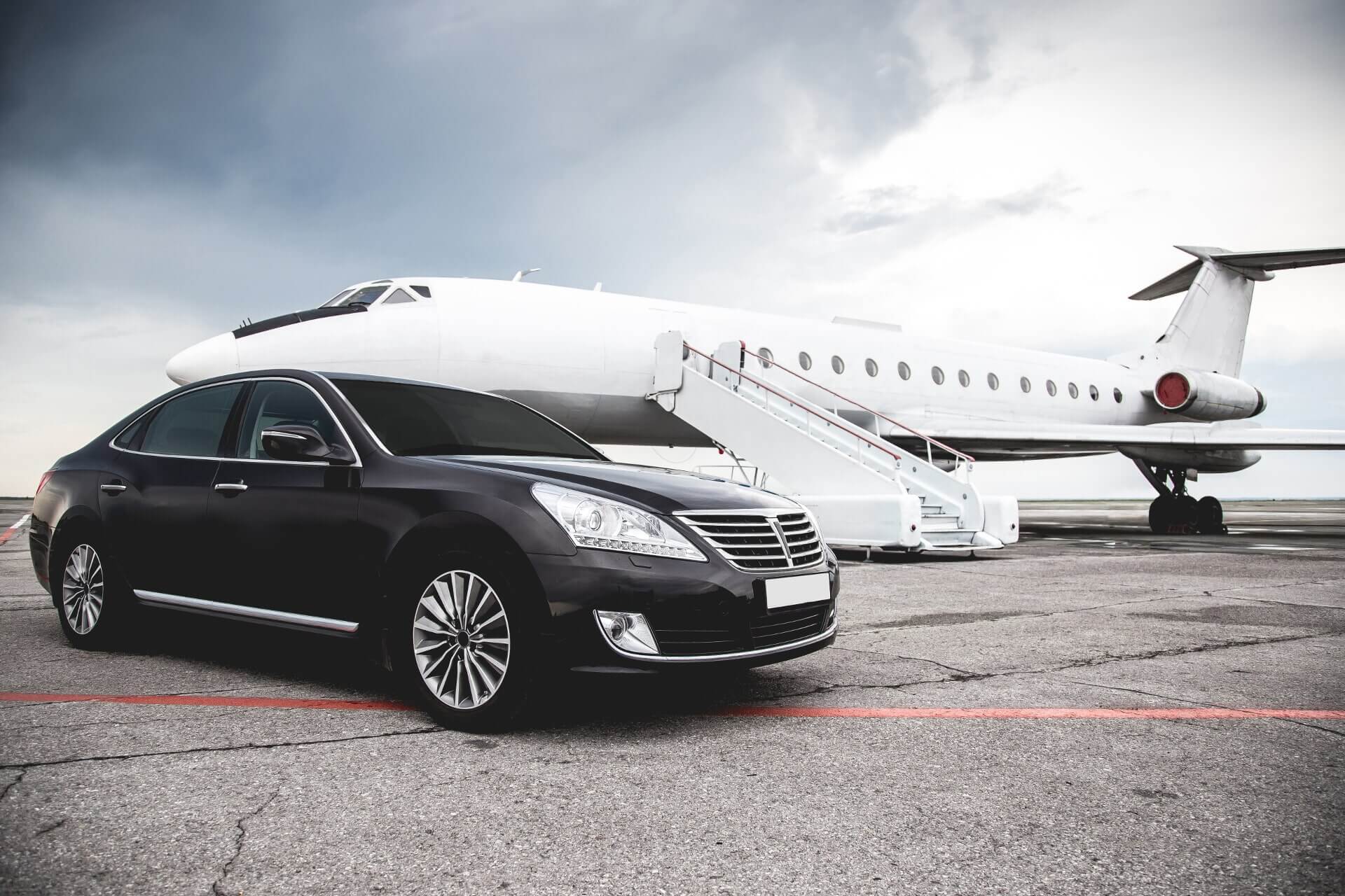 Luxury black car and private aircraft